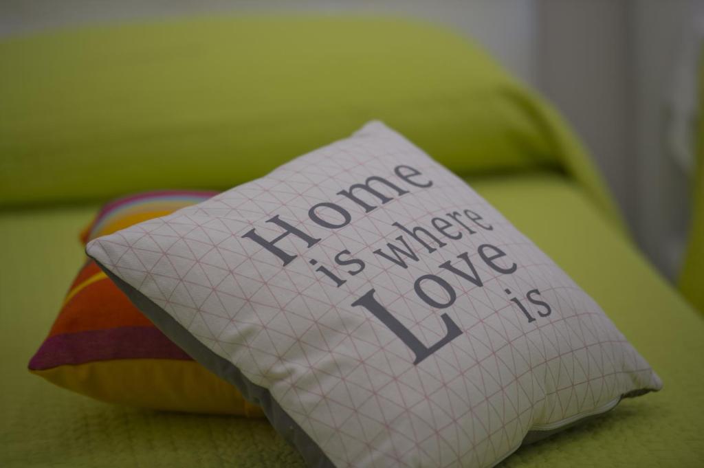 a pillow with the words home is where one is at Appartamenti Aria di Verde in Agerola