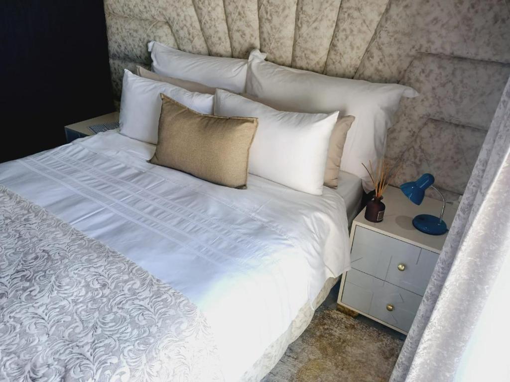 - un lit avec des draps et des oreillers blancs dans l'établissement Danko baba guest house & etc., à Welkom