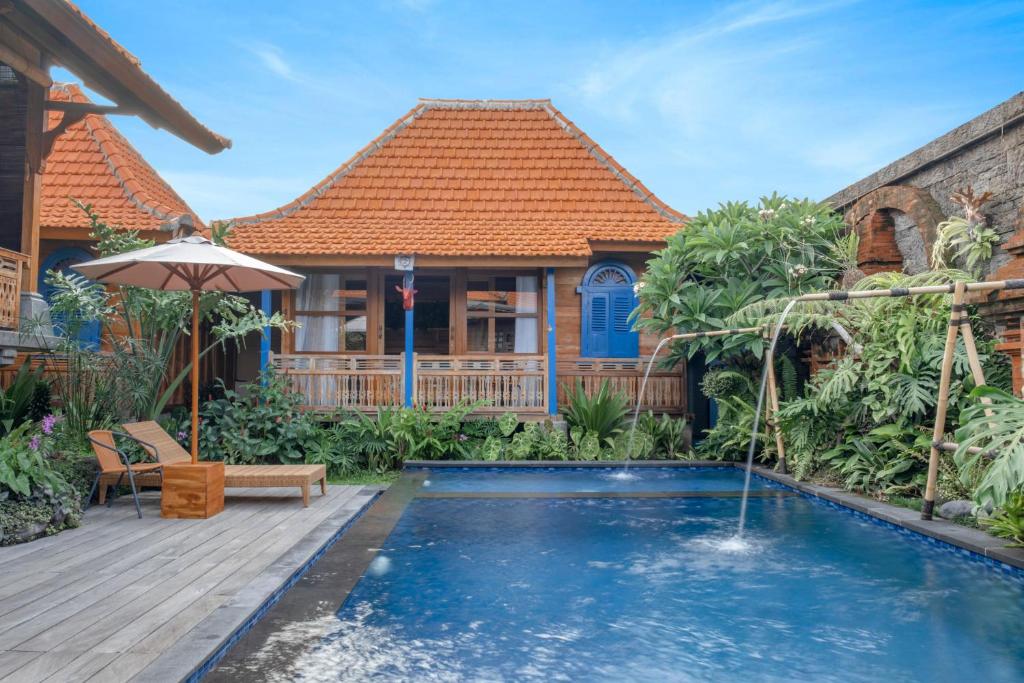 a house with a swimming pool and a wooden deck at Taman Prabhawa in Sukawati