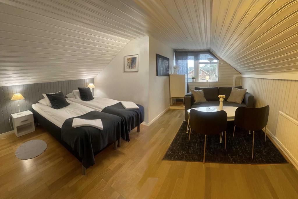 een slaapkamer met een bed en een tafel en stoelen bij Hotell Briggen i Åhus in Åhus
