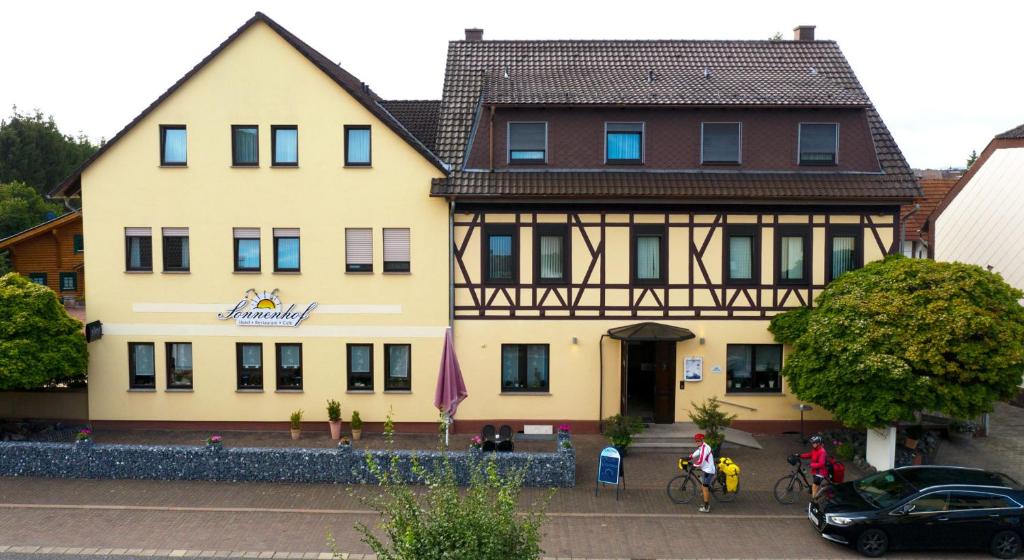 ein großes gelbes Gebäude mit braunem Dach in der Unterkunft Hotel Sonnenhof in Obersuhl