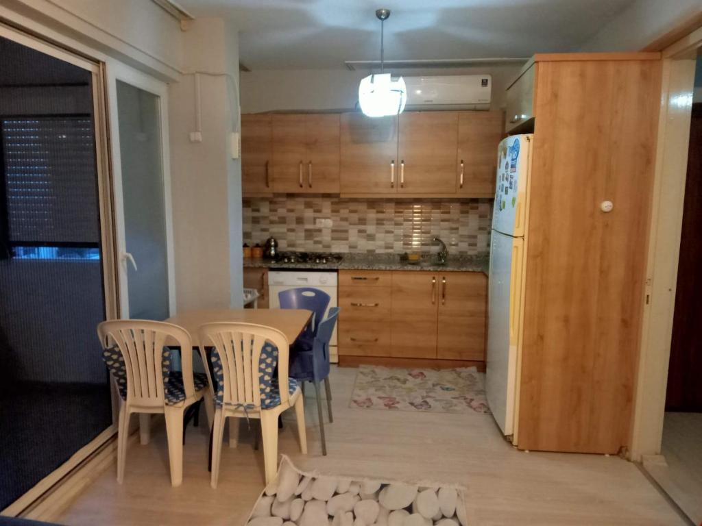uma cozinha com uma mesa e cadeiras e um frigorífico em Efehause em Edremit