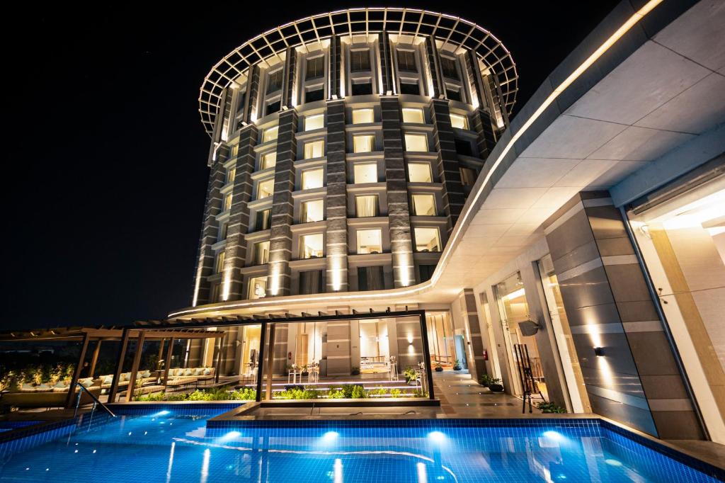 a large building with a swimming pool in front of it at LYFE HOTEL in Bhubaneshwar