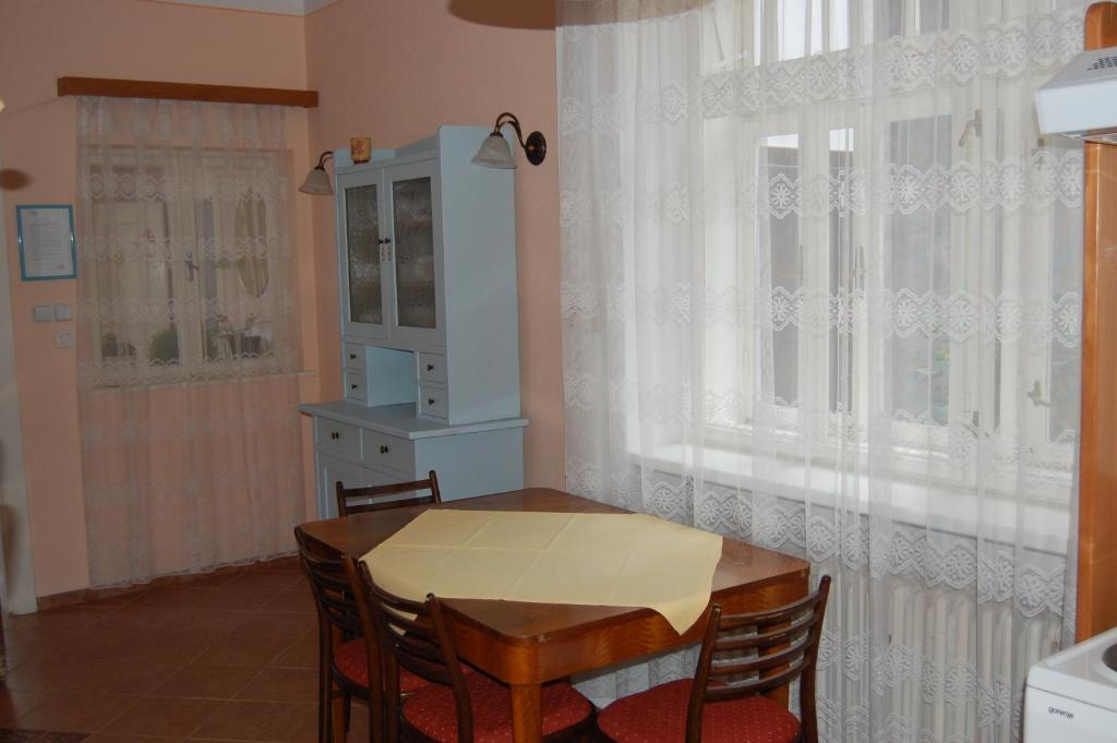 a dining room with a table and chairs and a window at Guest house Hošek in Senorady