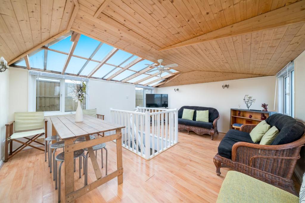 uma ampla sala de estar com tecto em madeira em ALTIDO Cosy maisonette near Abbey Road em Londres