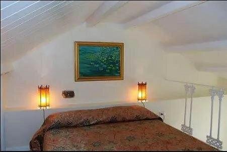 Un dormitorio con una cama con dos luces. en Casa di Ida, en Locri