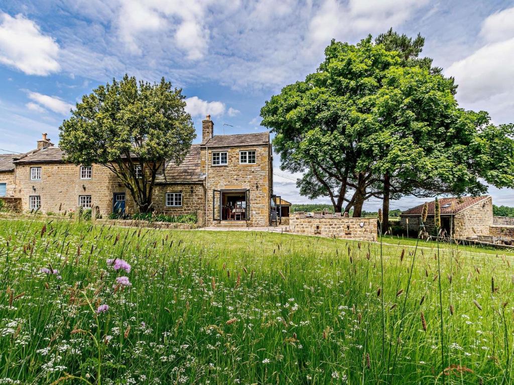 an old stone house with a field of grass at 8 Bed in Ripon 72263 in Grantley