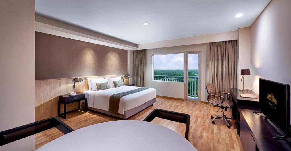 カラワンにあるデロニクス ホテル カラワンのベッドと大きな窓が備わるホテルルームです。