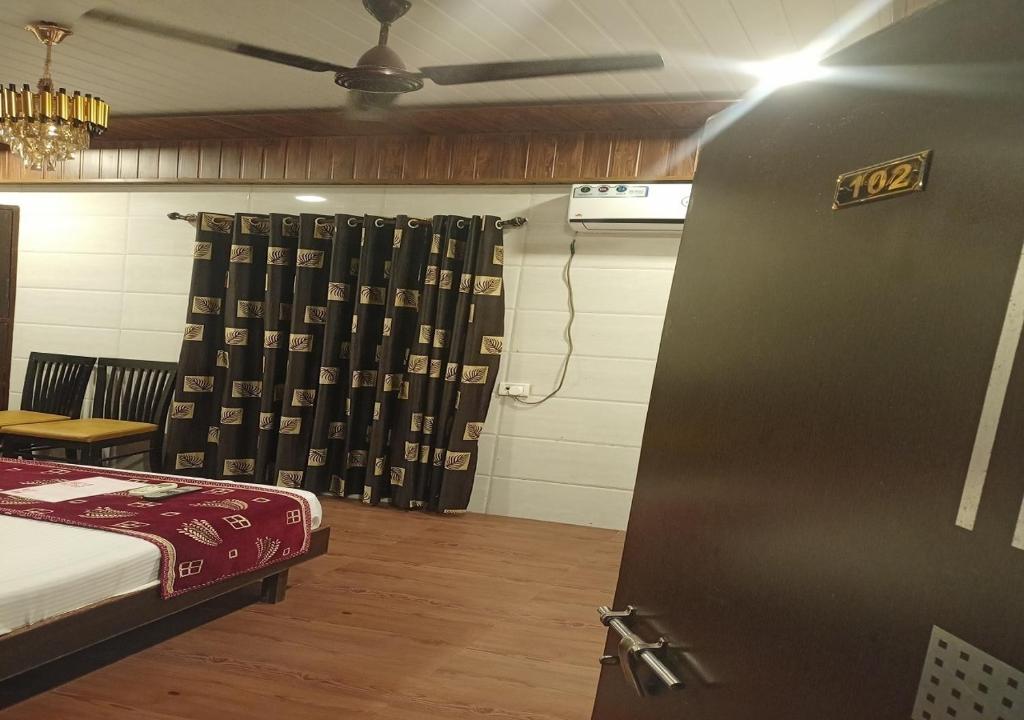 Zimmer mit einem Bett und einer Tür mit einem Vorhang in der Unterkunft Hotel Geetanjali St Bus Stand Panvel in Panvel