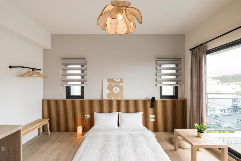 Un dormitorio con una cama grande y una lámpara de araña. en Chunns Inn, en Hengchun