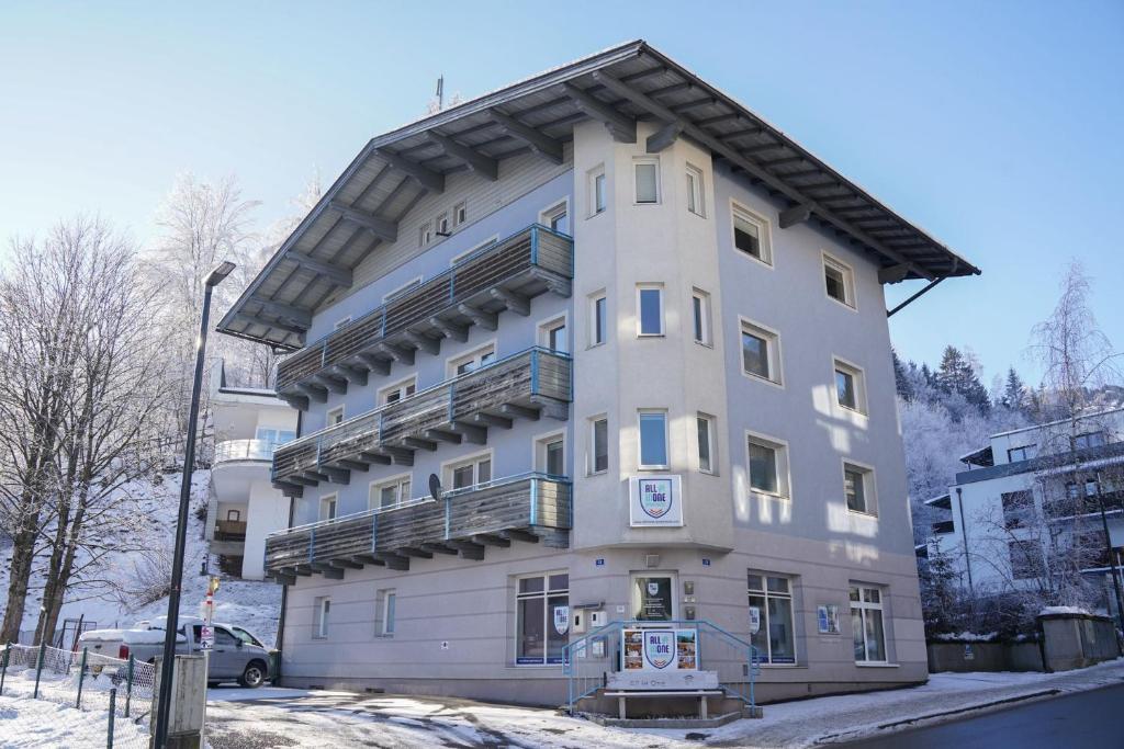 ein hohes weißes Gebäude mit einem Balkon in der Unterkunft Schlafgut Küssler - 70m vom City Express in Zell am See