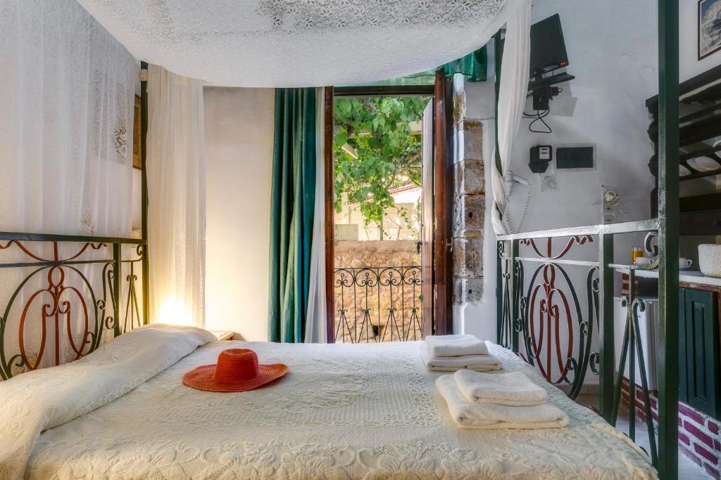 a bed with two towels and a hat on it at IFIGENIA ROOMS BY MARIOS in Chania Town