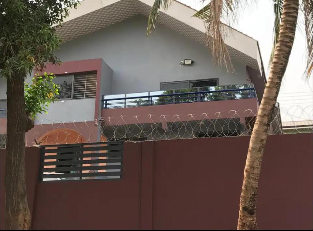 a house with a fence in front of it at Calm Hillside Swimming Pool Villa Apartment in Accra