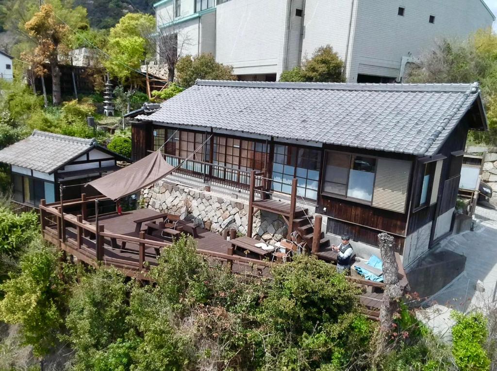 uma vista aérea de uma casa com um deque em 城跡石垣上の絶景古民家宿 鞆城茶屋庵 em Tomo