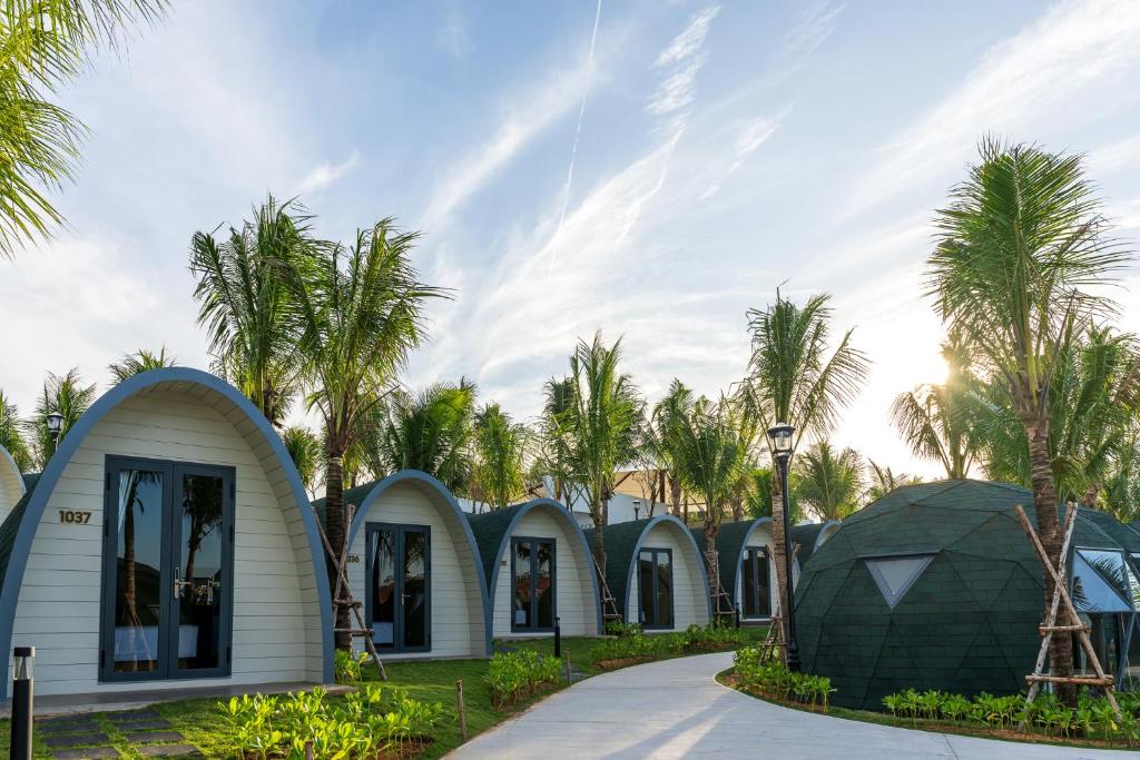 uma fila de casas abobadadas com palmeiras ao fundo em Wonderland Resort Phan Thiet em Phan Thiet