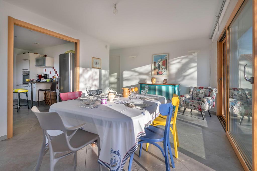 a dining room with a white table and chairs at Pause, detente et partage a Pornichet in Pornichet