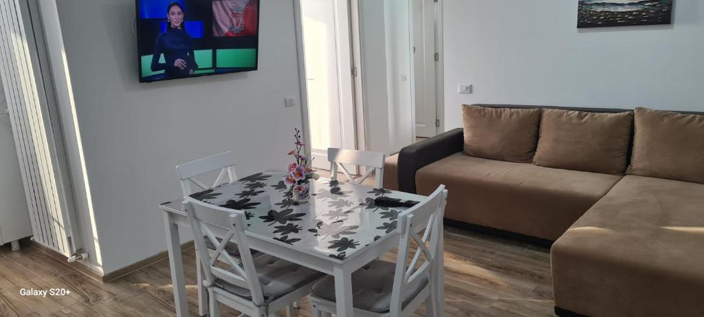 uma sala de estar com uma mesa e um sofá em Apartament Lucian em Râmnicu Vâlcea