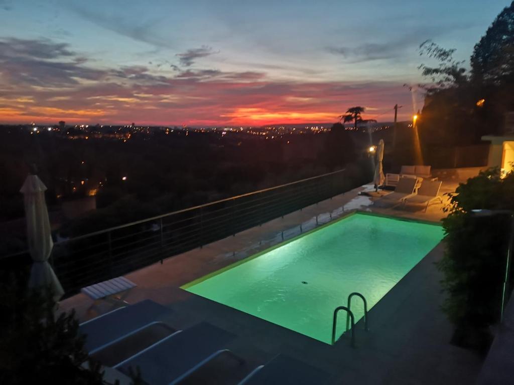 a swimming pool with a sunset in the background at Plus Belle La Vue Allauch in Allauch