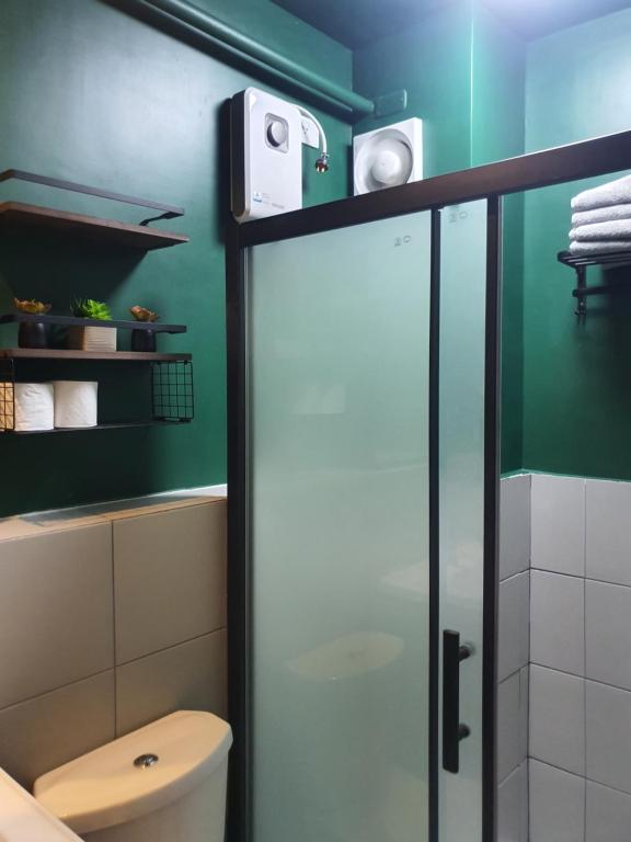 マンダウエ・シティにある2BR condo at banilad cebu 650のバスルーム(トイレ、ガラス張りのシャワードア付)