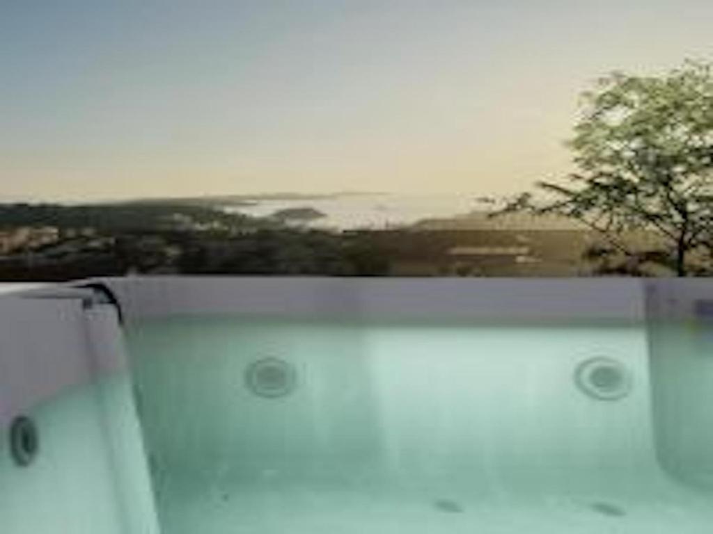 a view of a window with a tree in the background at Luxury Penthouse Hvar with Jacuzzi & Sea View in Hvar
