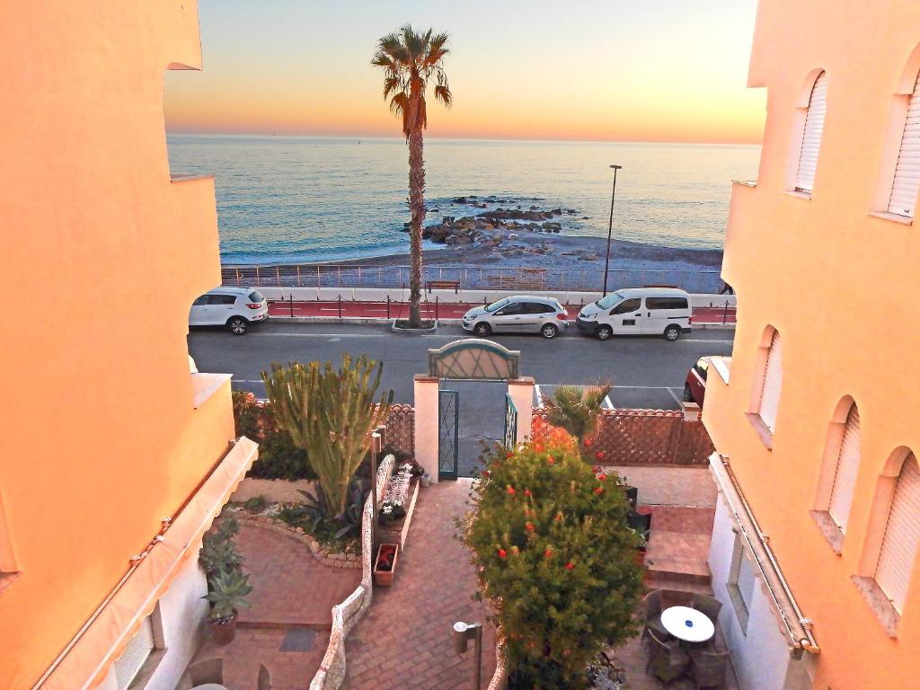 a view of the ocean from between two buildings at Hotel Kaly in Ventimiglia