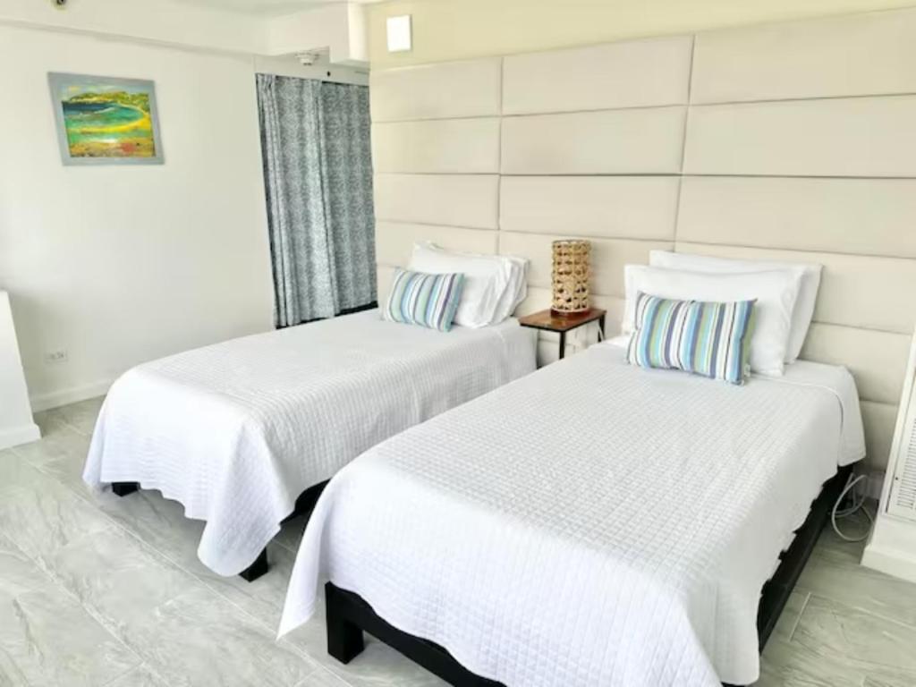 2 Betten in einem Zimmer mit weißer Bettwäsche in der Unterkunft Waikiki Ocean View Penthouse 2/2 bdr/bath in Honolulu