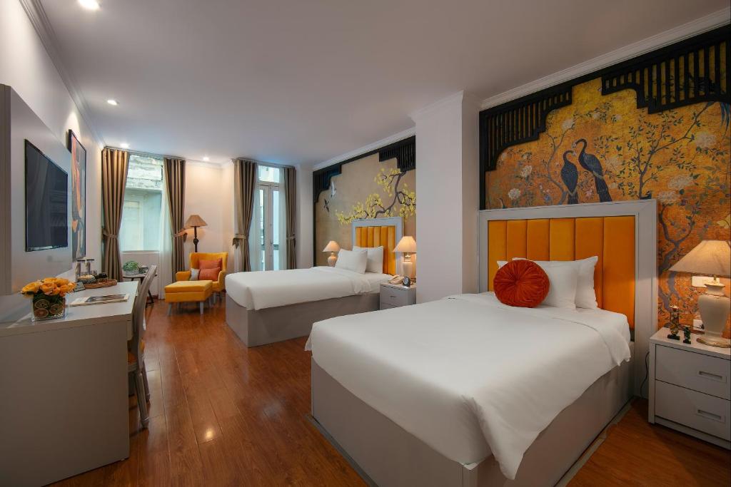 ein Hotelzimmer mit 2 Betten, einem Schreibtisch und einem Zimmer in der Unterkunft San Hanoi Hotel in Hanoi