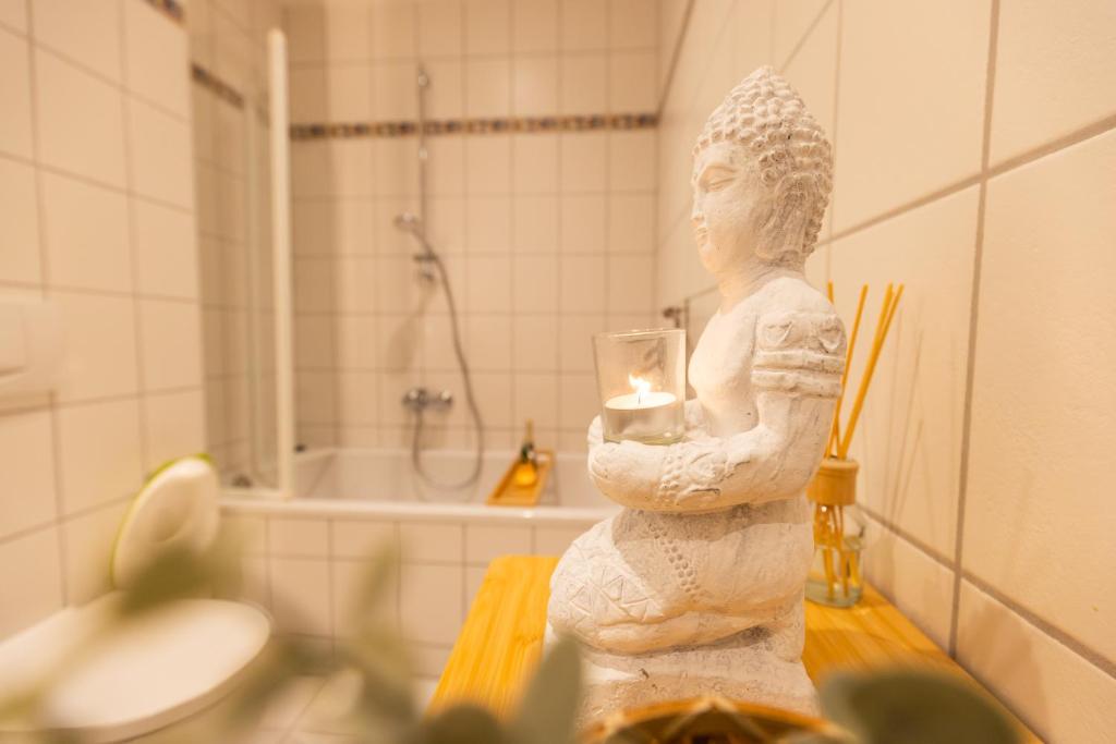 a statue of a woman holding a candle in a bathroom at Herzraum Appartement Bautzen, Innenstadtlage,WIFI, gratis Kaffee und Tee, Babybett in Bautzen