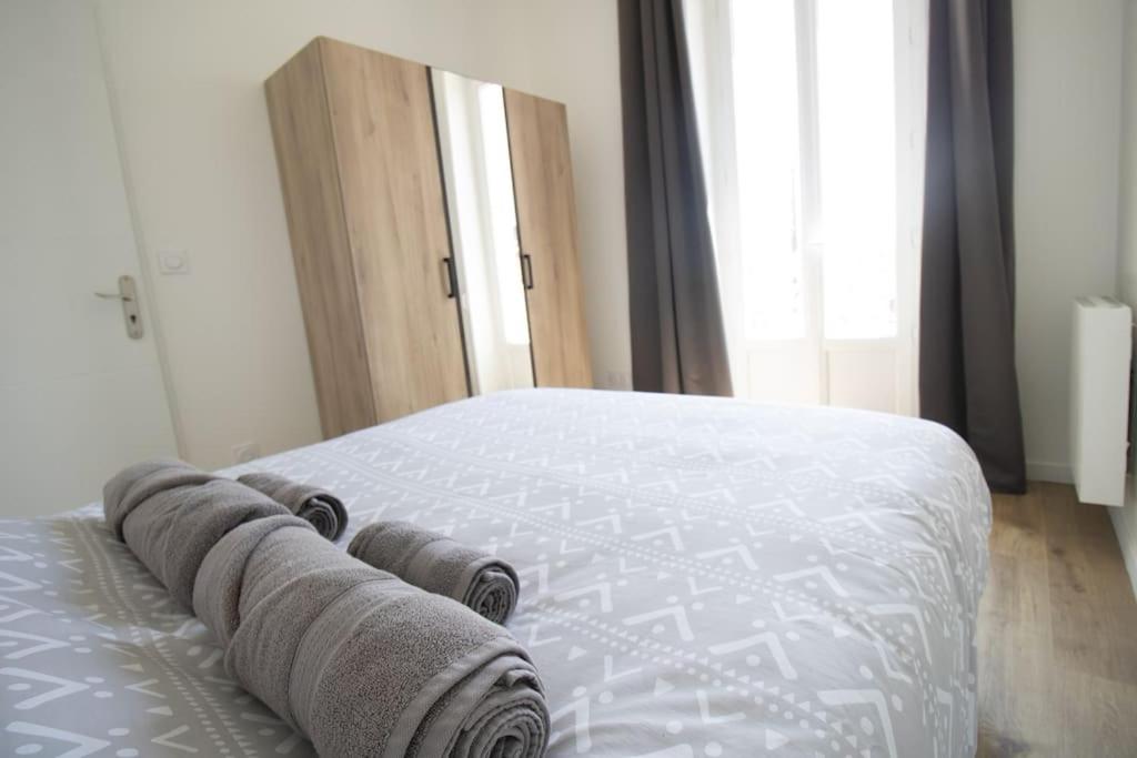 a bed with towels on it in a bedroom at Le Logis de la Gare - 4 min à pied de la gare in Bourg-en-Bresse