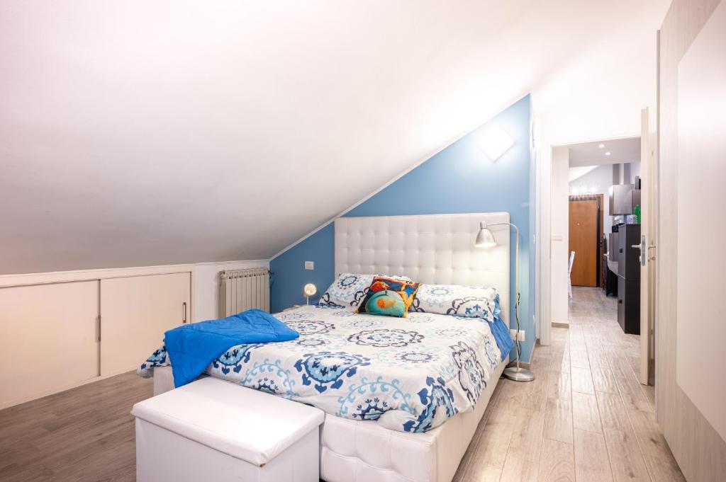 a blue and white bedroom with a bed and a staircase at Parma Elegant and Sweet Apartments in Parma