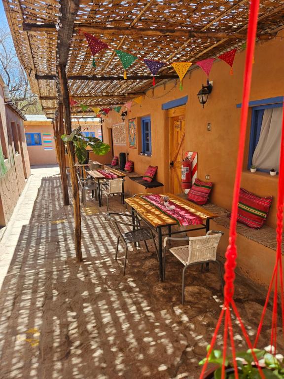 a patio with a table and chairs under a roof at Hostal Likancabur in San Pedro de Atacama