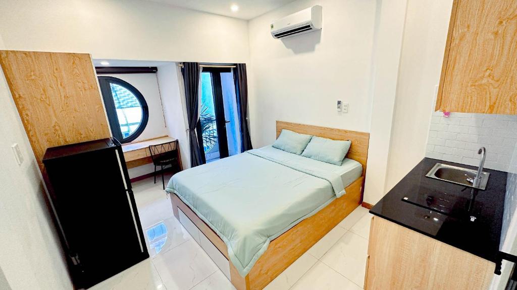 Kleines Zimmer mit einem Bett und einem Waschbecken in der Unterkunft Lucy House in Ho-Chi-Minh-Stadt