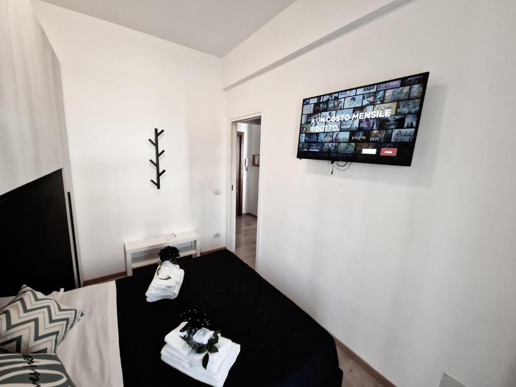 a room with a table and a tv on a wall at Ostia Sunset in Lido di Ostia
