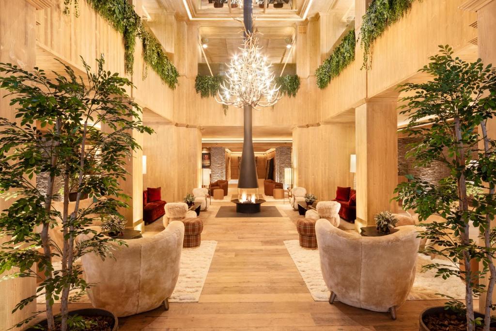 a lobby with chairs and trees in a building at Hotel MIM Baqueira Luxury & SPA in Baqueira-Beret