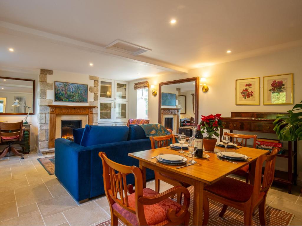 a living room with a table and a blue couch at Sundown Lodge in Chipping Campden