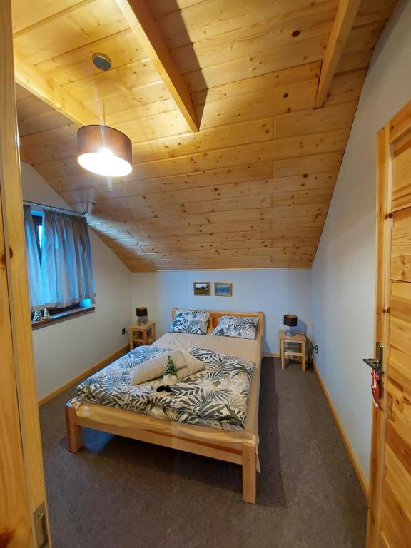 1 dormitorio con 1 cama en una habitación con techos de madera en Zwardoniówka Apartamenty pod Orawcową en Zwardoń