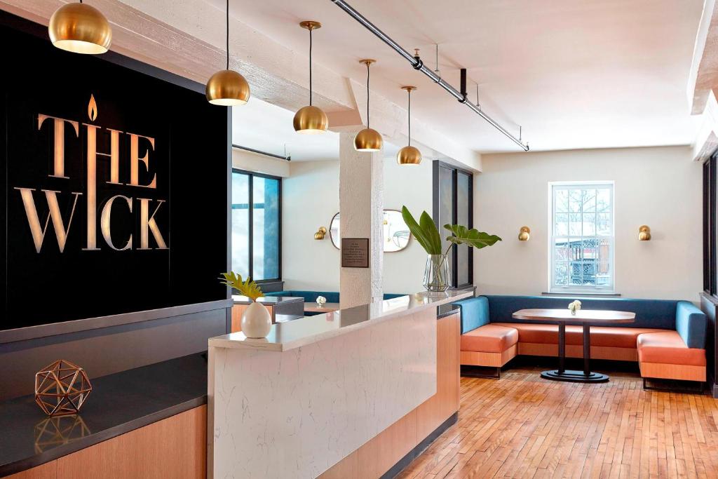 a lobby with a waiting area with a sign that reads the wolf at The Wick, Hudson, a Tribute Portfolio Hotel in Hudson