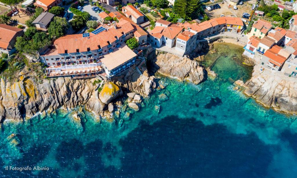 una vista aerea di un resort su una scogliera vicino all'oceano di Hotel Saraceno a Giglio Porto