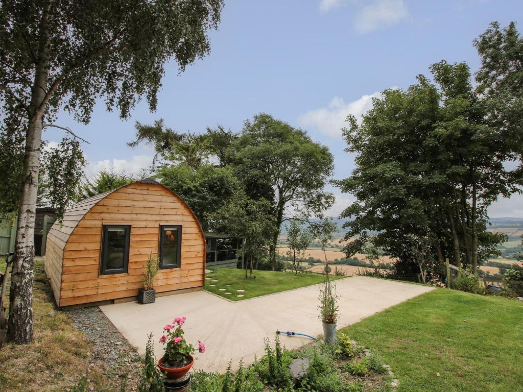 mały drewniany domek w ogrodzie z drzewami w obiekcie The Pod w mieście Shrewsbury