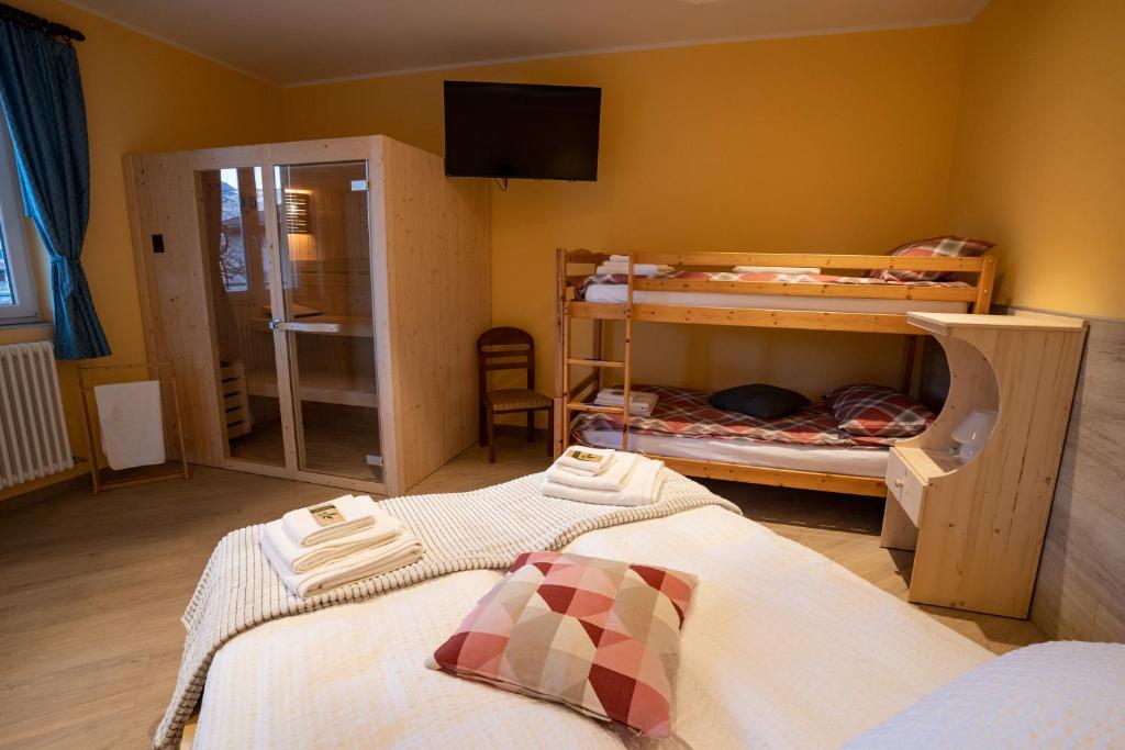 a bedroom with two bunk beds and a television at Villa Zoe - Suite con Sauna in Margone