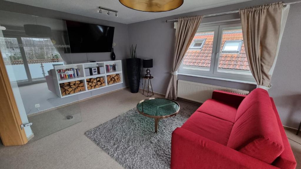 uma sala de estar com um sofá vermelho e uma televisão em Creating Memories em Titisee-Neustadt