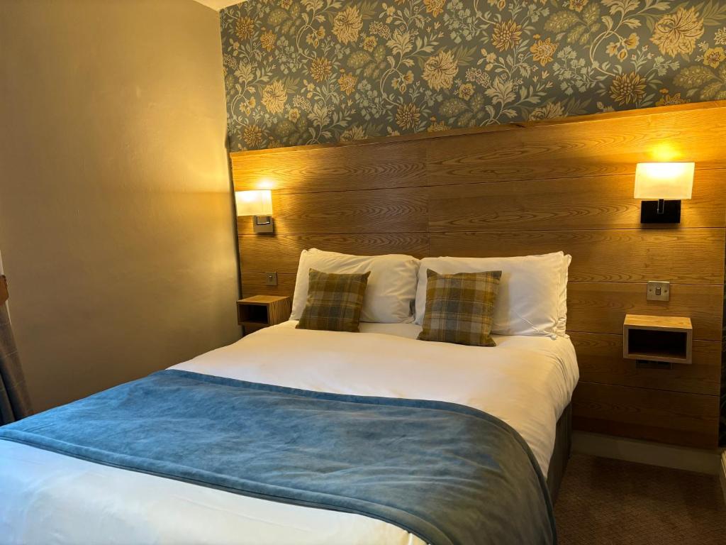 a hotel room with a large bed with two pillows at Snooty Fox in Kirkby Lonsdale