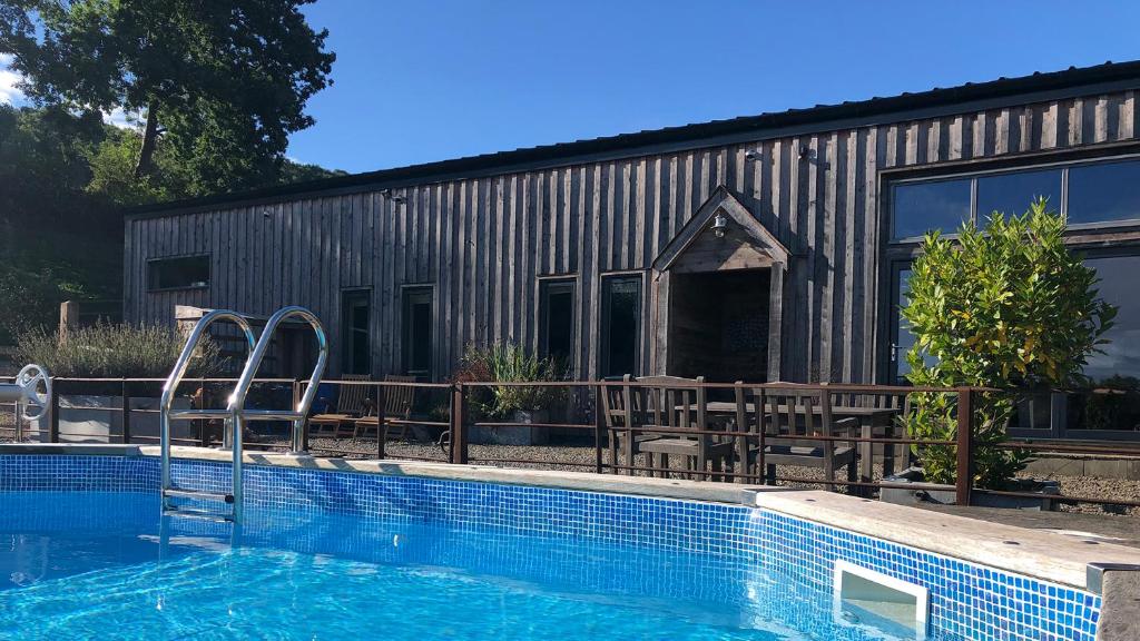 una casa con piscina al lado de un edificio en Outshot Barn, en Hay-on-Wye