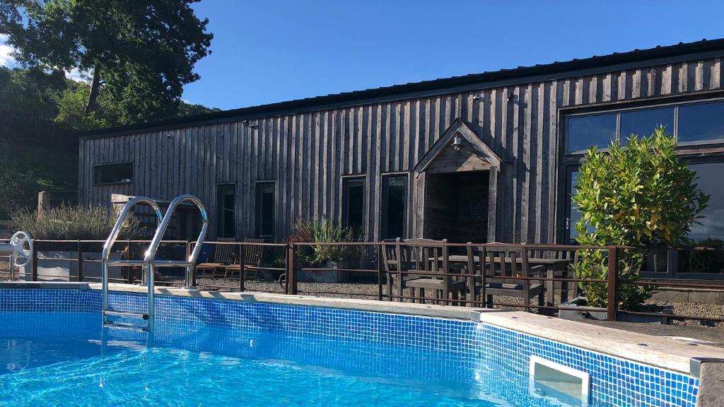 a house with a swimming pool next to a building at Outshot Barn in Hay-on-Wye