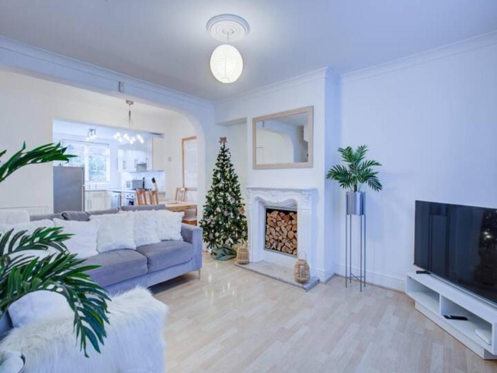 uma sala de estar com um sofá e uma árvore de Natal em Pass the Keys Charming 2 Bedroom House Good Transport and Parking em Londres