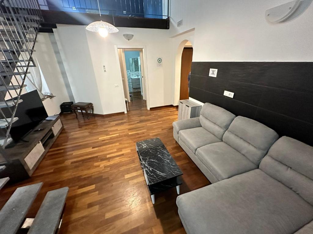 ein Wohnzimmer mit einem Sofa und einem Tisch in der Unterkunft Monfalcone by Arbaspàa in La Spezia