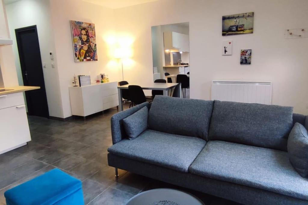 un salon avec un canapé bleu et une table dans l'établissement Chalet cosy en centre-ville, au Puy-en-Velay