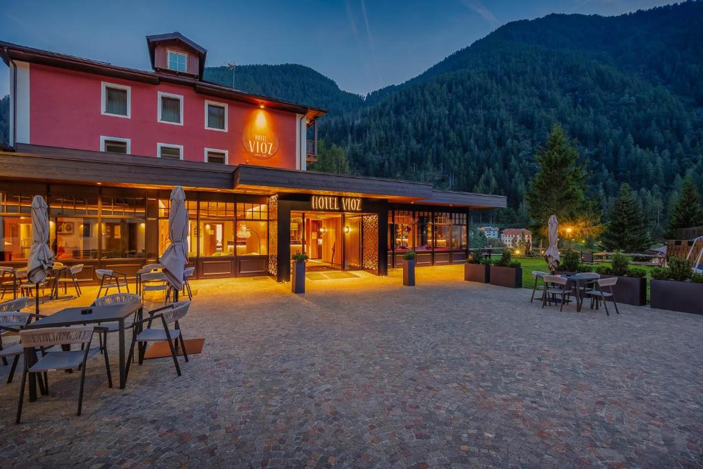 a hotel with tables and chairs in front of a building at Hotel Vioz in Peio Fonti