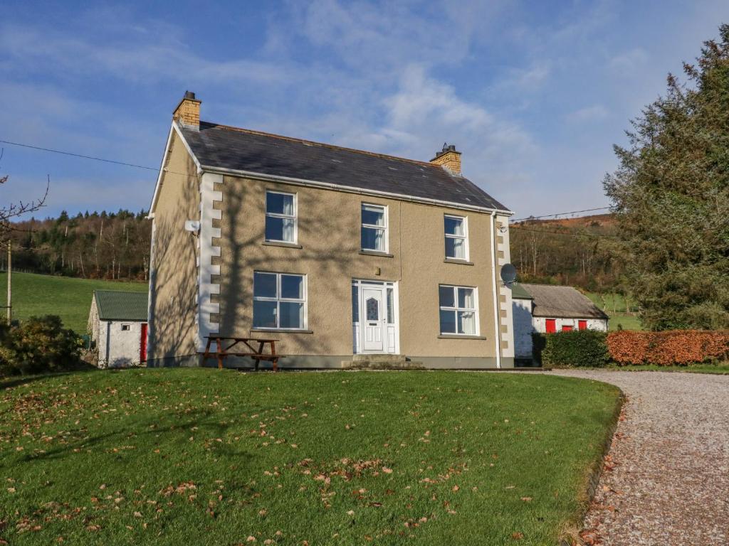 a house with a grassy yard in front of it at Alcorns Farmhouse in Letterkenny