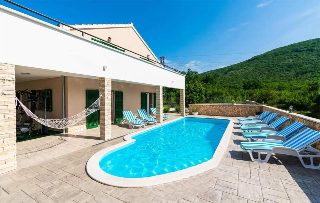 una piscina con sedie a sdraio accanto a una casa di Beautiful Home In Konjsko With Outdoor Swimming Pool a Konjsko